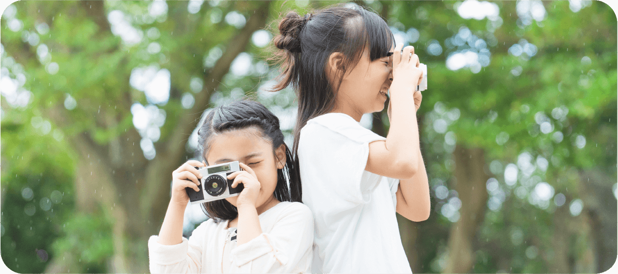 写真：女の子2人がカメラを構えてシャッターを押そうとしている